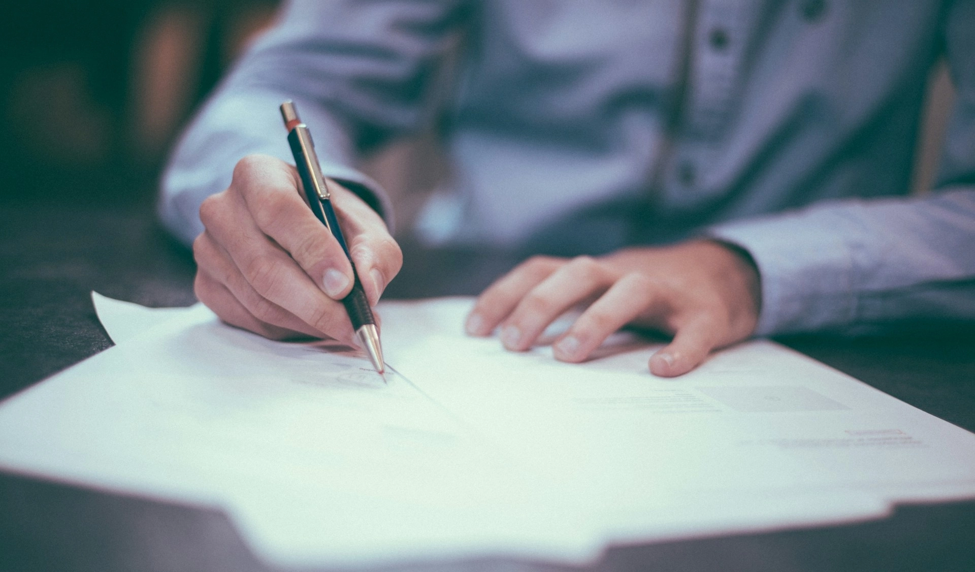 A man writing on paper.