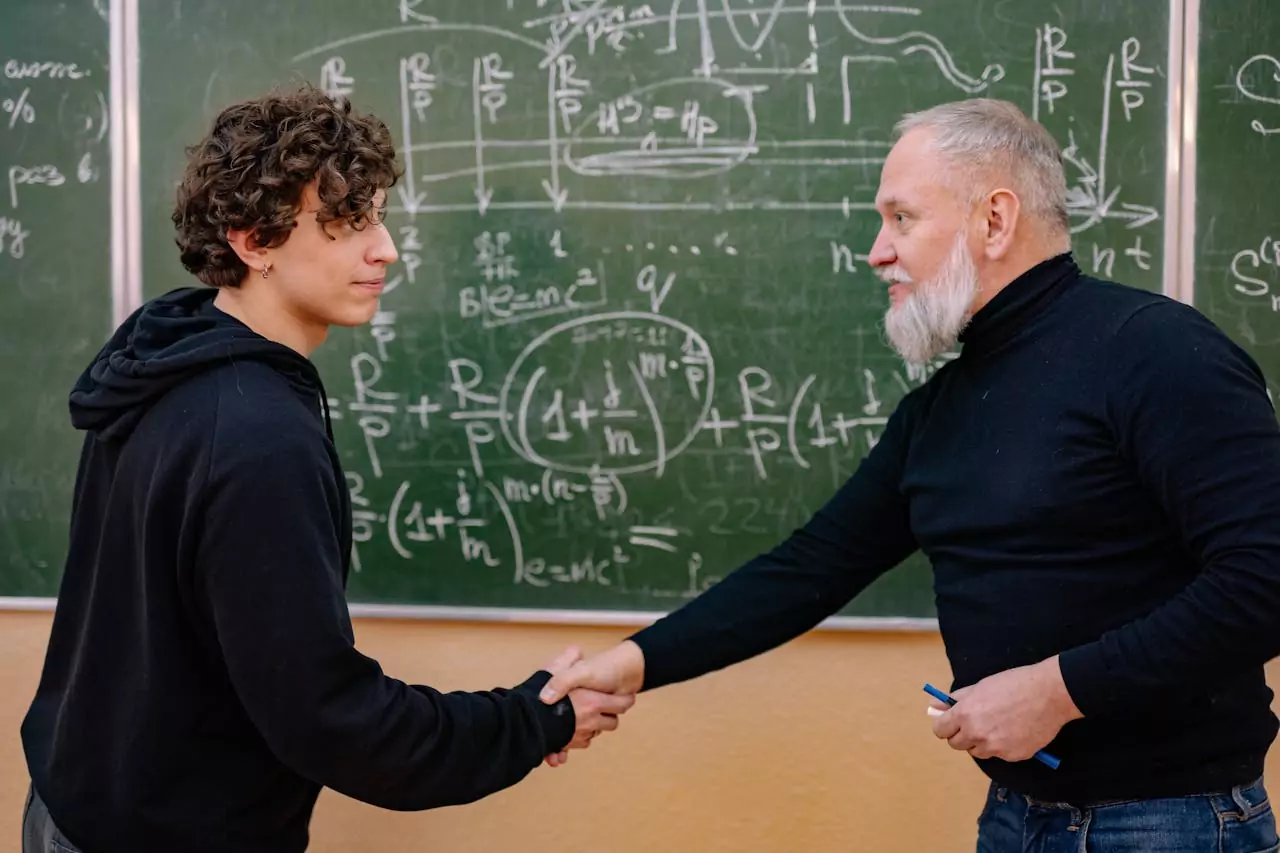 A professor shaking the hand of his student.