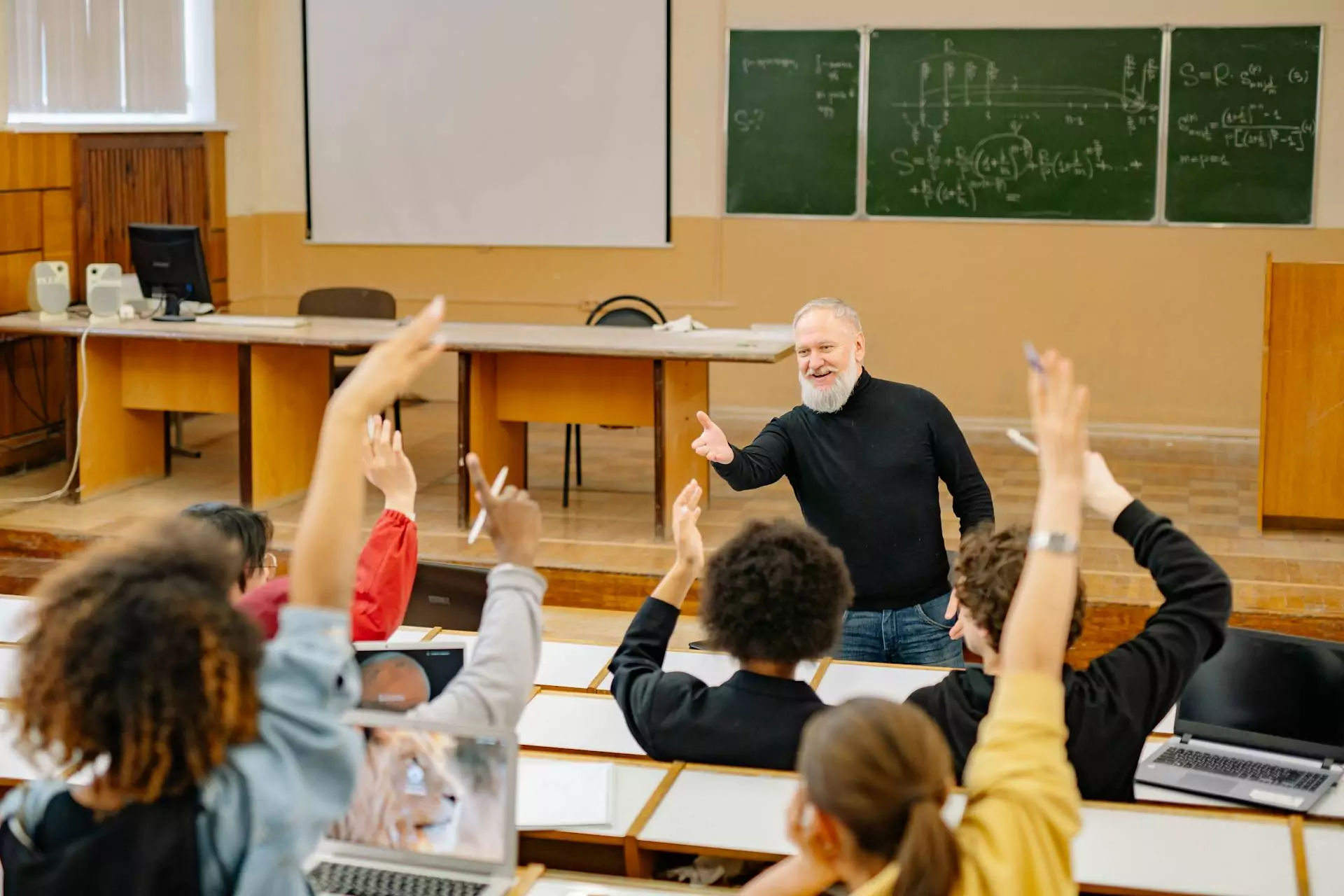 A group of students raising their hands to participate in class.