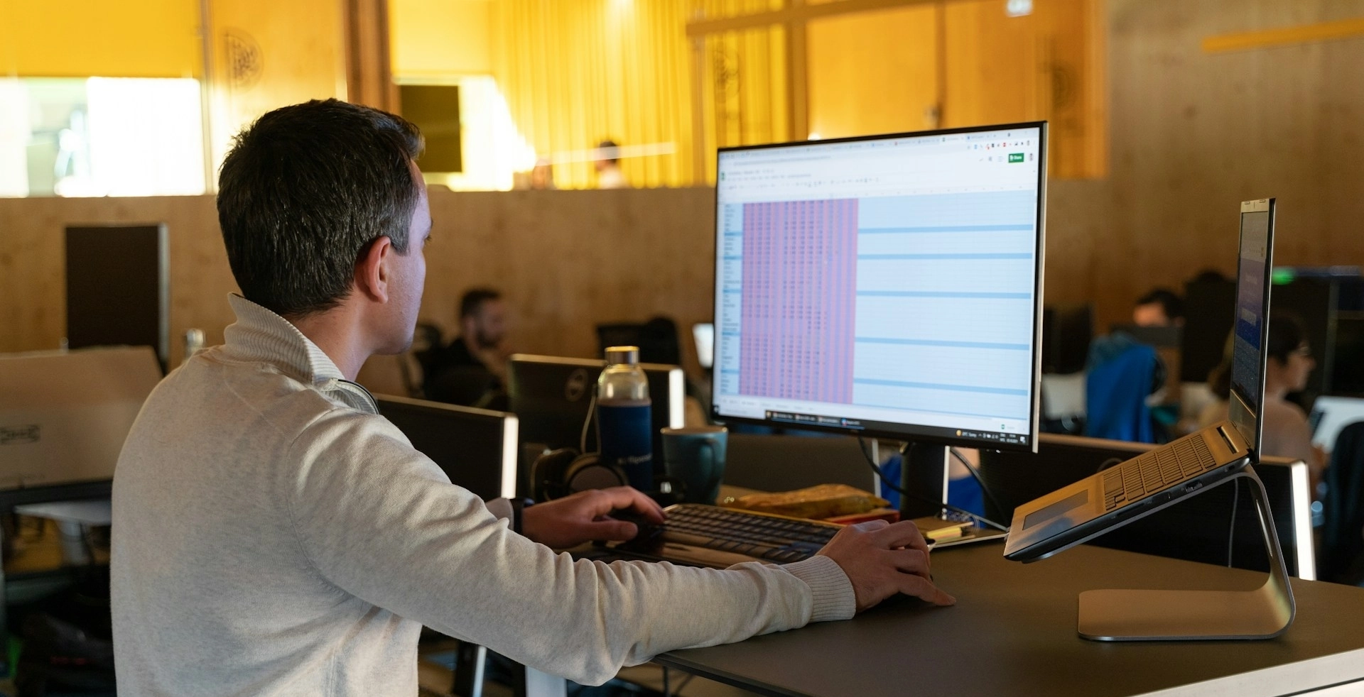 A man sits at a desk using a computer.