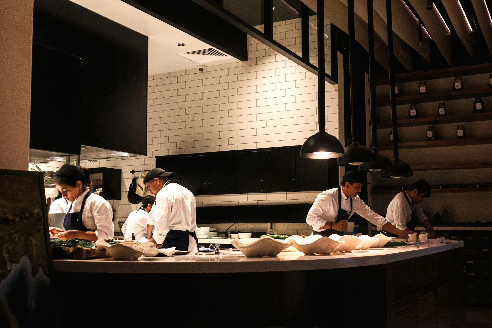 Chefs working in a clean and modern restaurant kitchen.