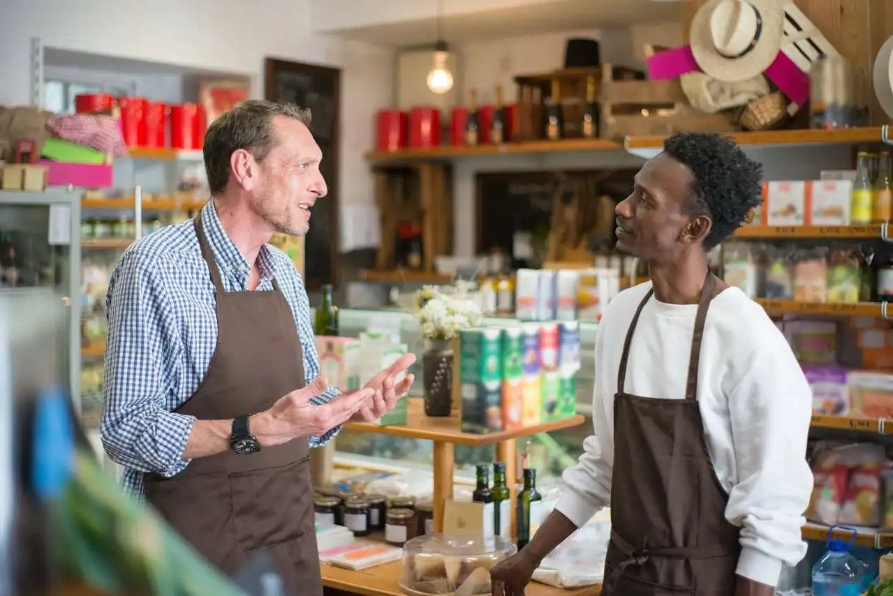 Two men talking inside a grocery store.