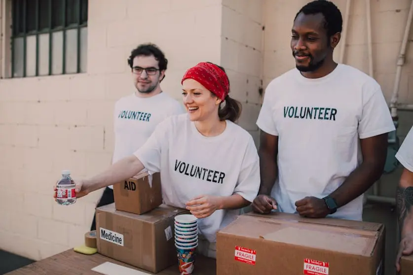 Three people donating goods for charity.