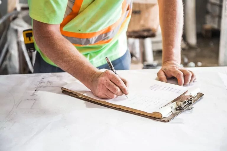 Construction worker manually completing paper based time card