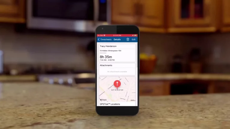 ClockShark GPSTrak dashboard shown on a mobile phone against a domestic background
