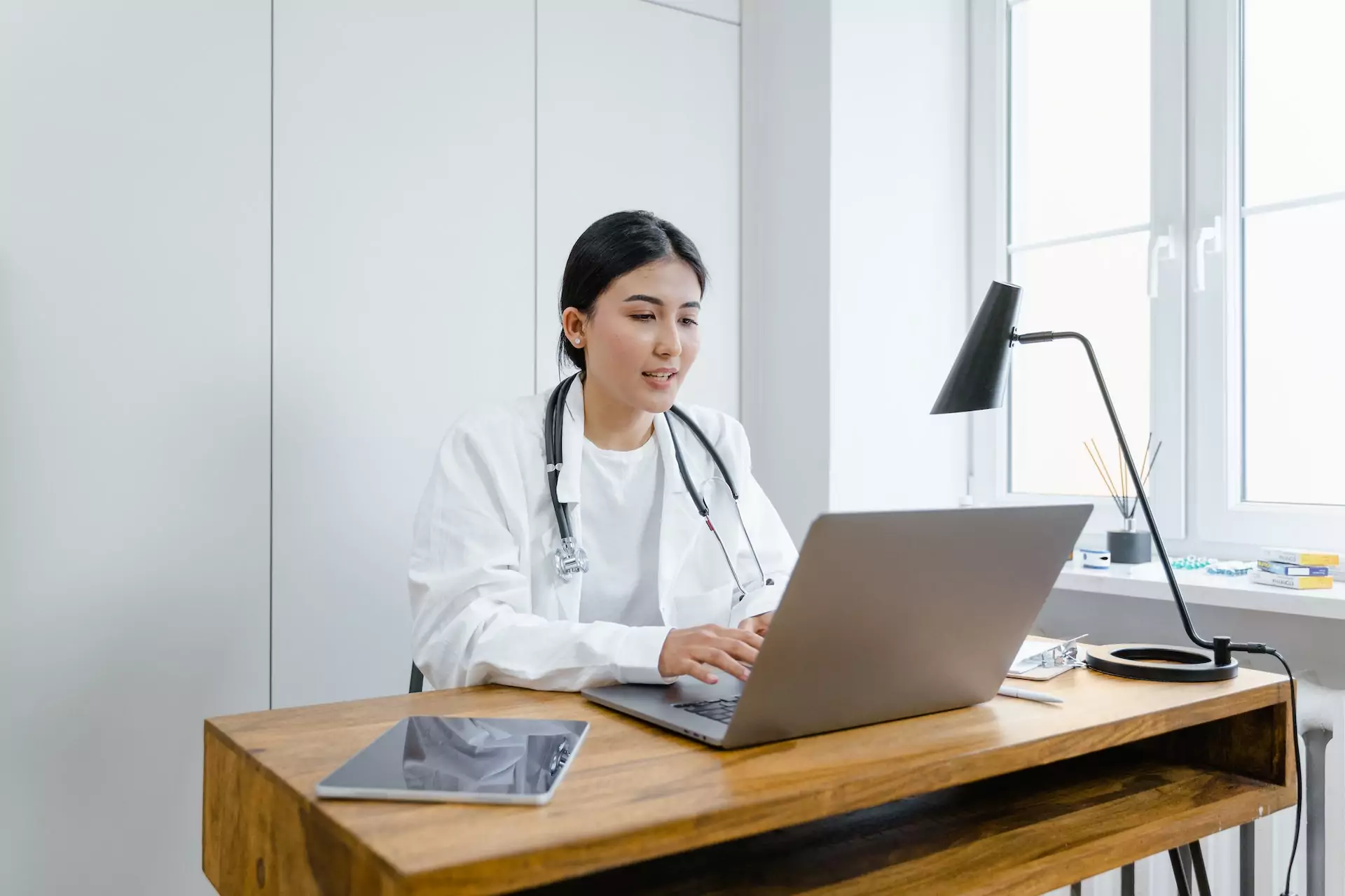 Gestión del tiempo para médicos. Foto de Tima Miroshnichenko: https://www.pexels.com/photo/a-woman-in-white-coat-using-a-macbook-8376232/