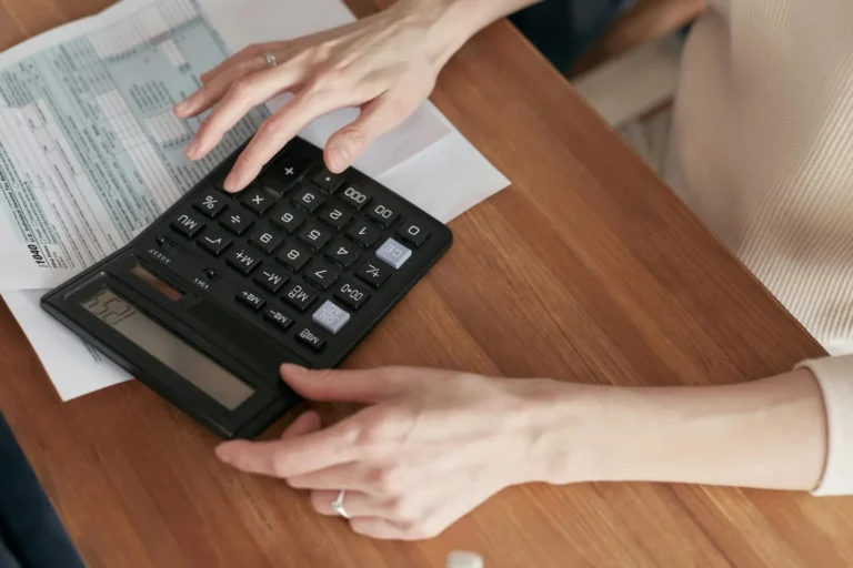 Mani che digitano su una calcolatrice.