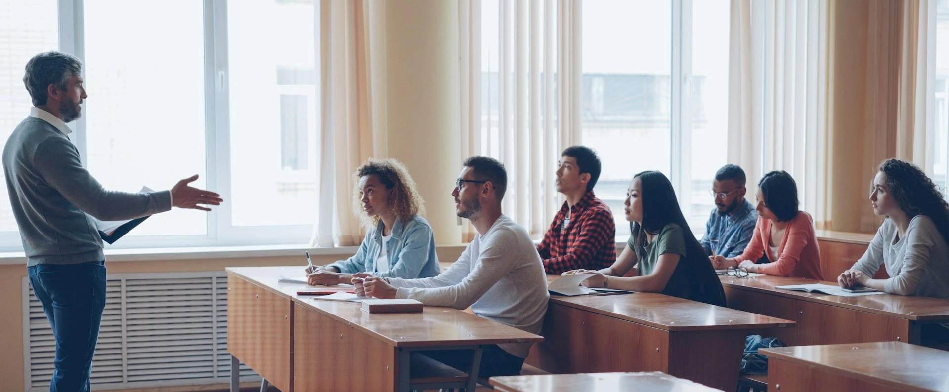 A teacher lectures students in a classroom.