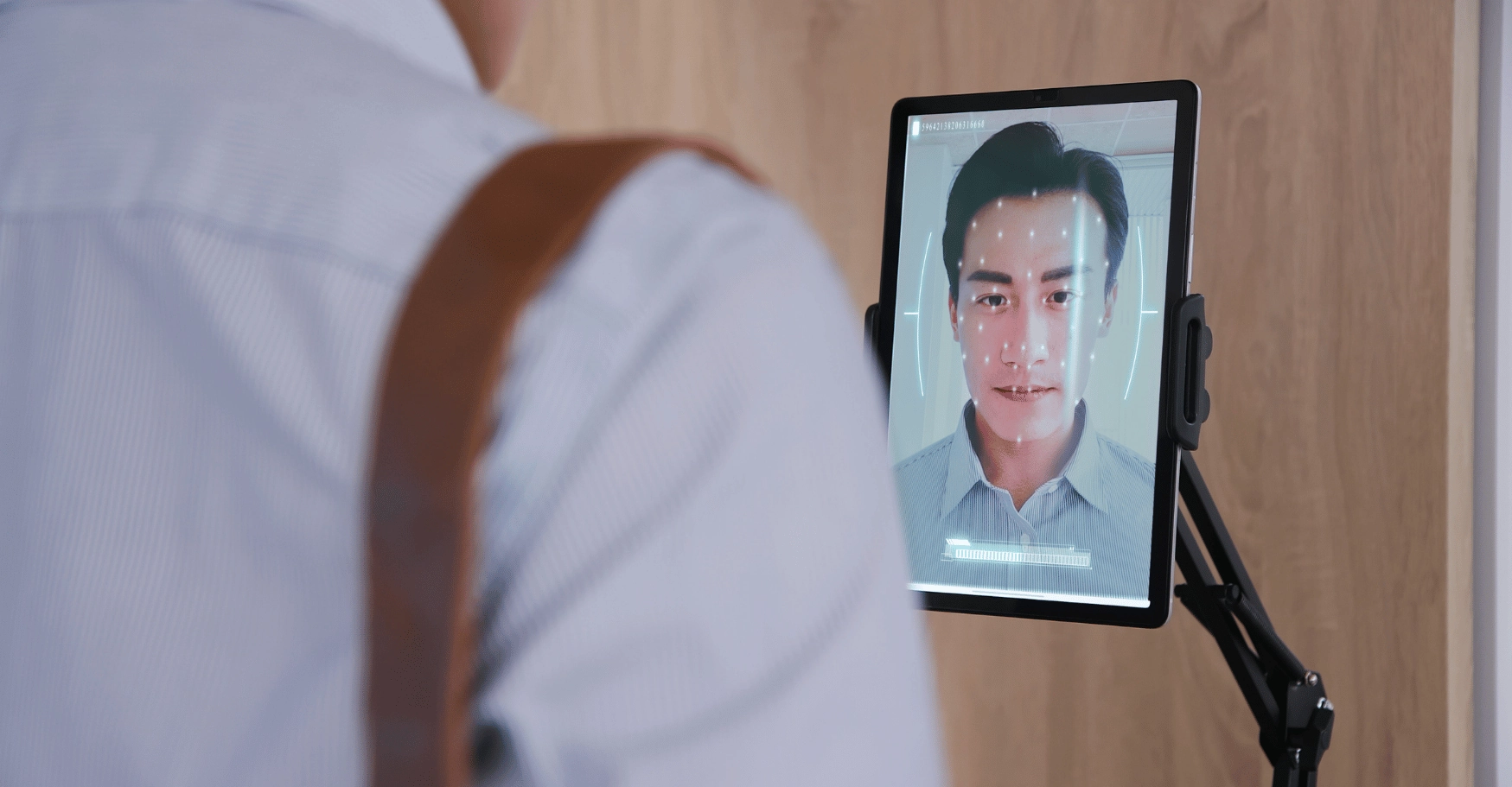 A man scanning his face to clock in at work.