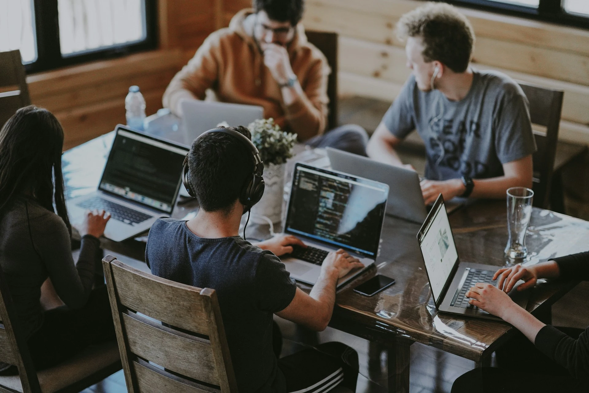 A group of people using their laptop computer on a shared table.