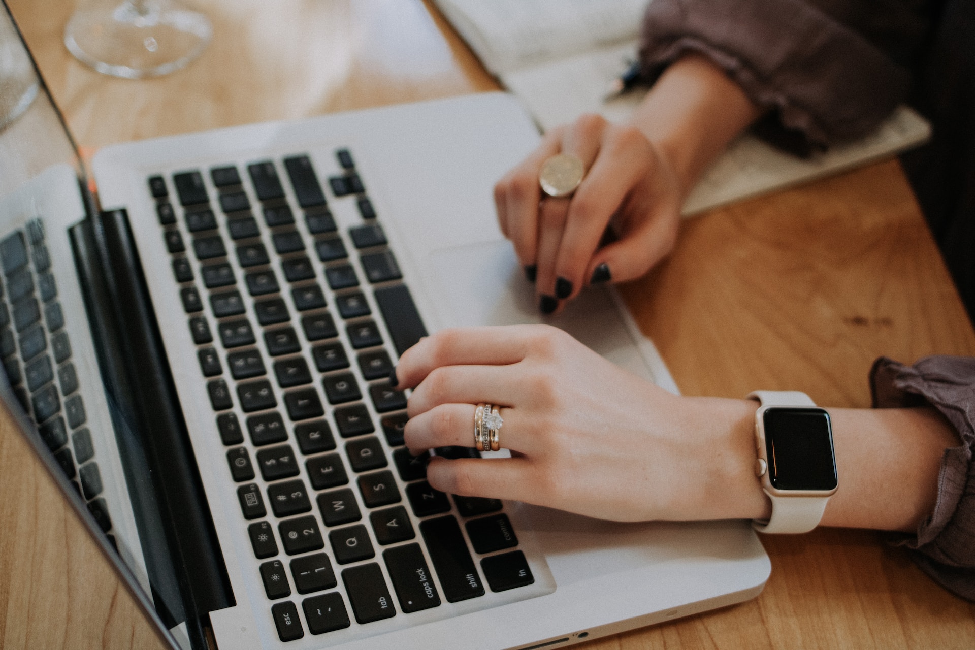 Hands typing on laptop keyboard. Writing content to dominate time tracking.