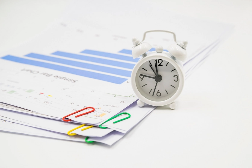 Une horloge et du papier représentant le suivi du temps dans une organisation