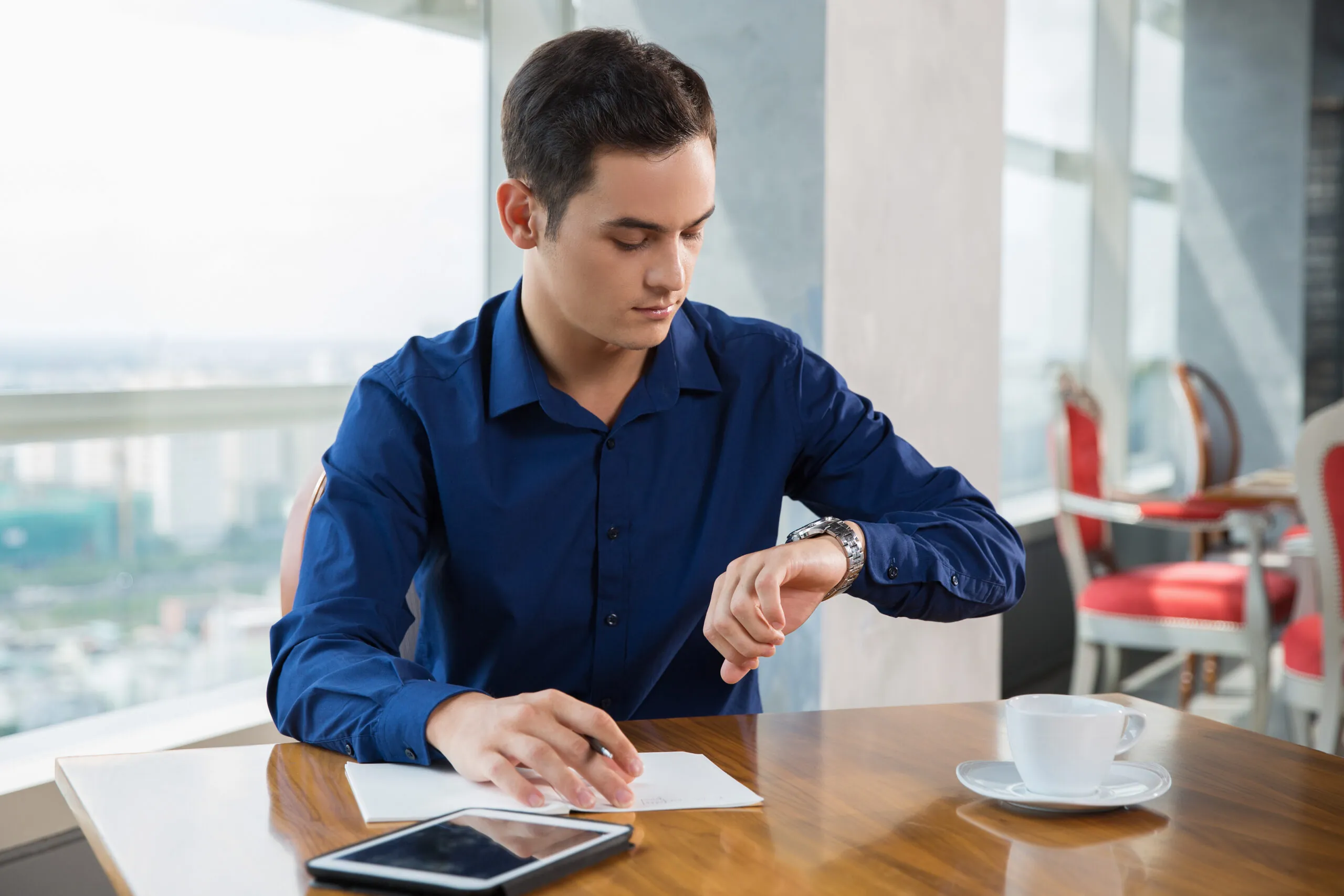 Consultant looking at a wristwatch while working.
