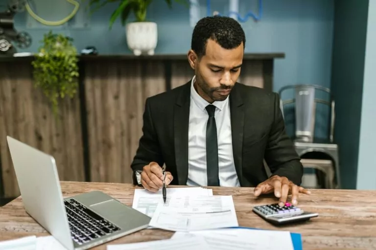 A man working and calculating something on his calculator.