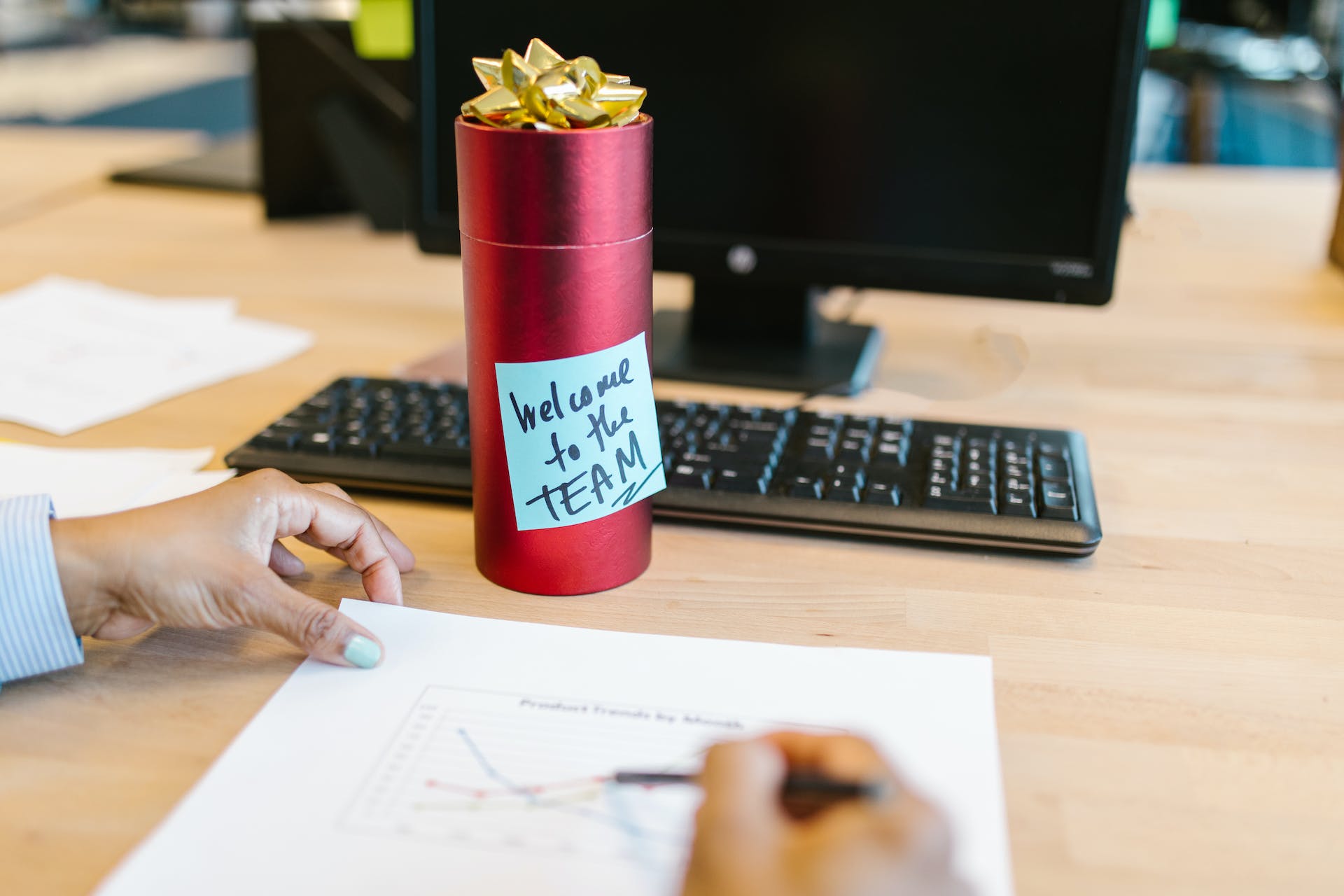 A welcome gift to a new employee with a note stuck to it that says "Welcome to the team!"