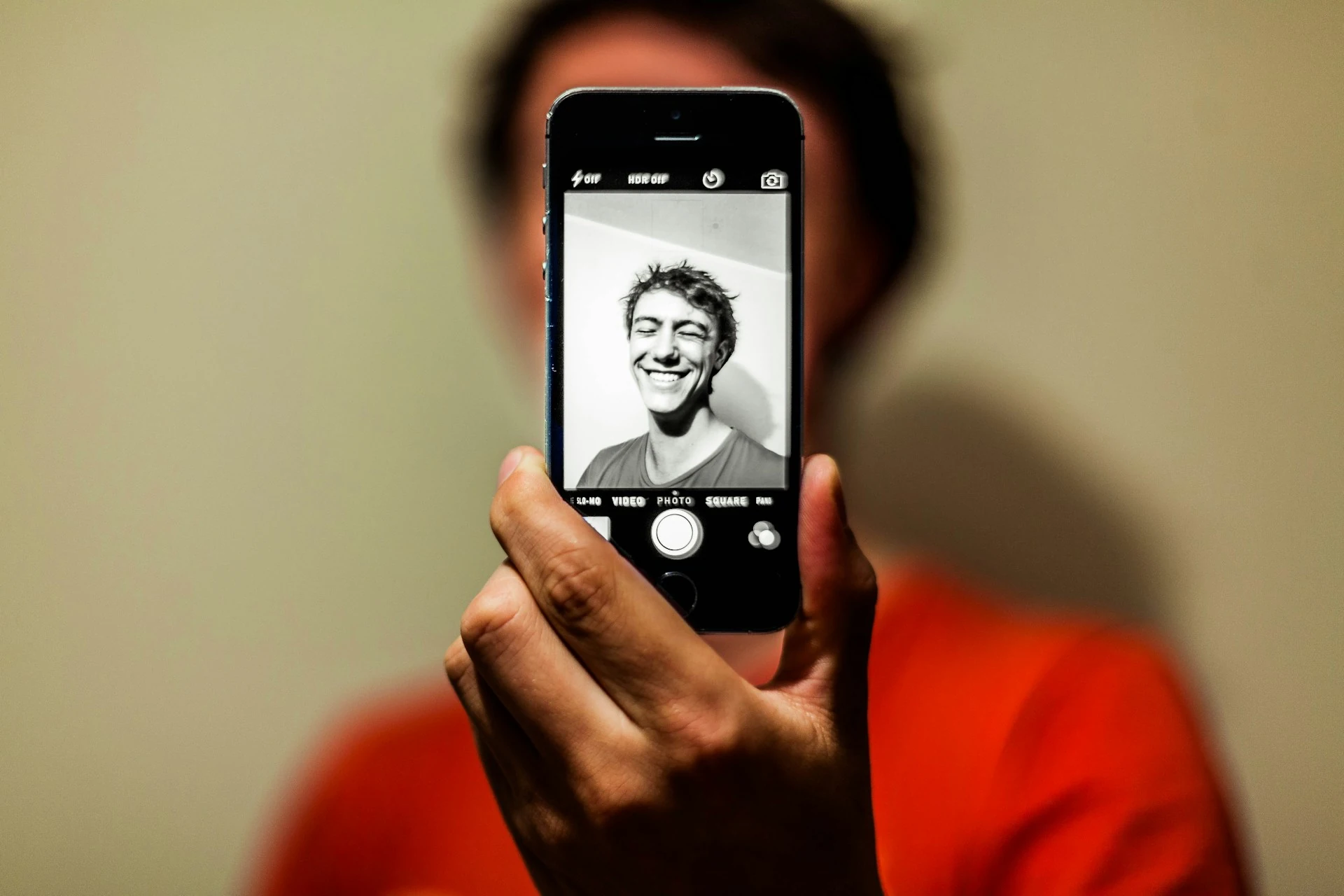 A guy taking a selfie using his phone.
