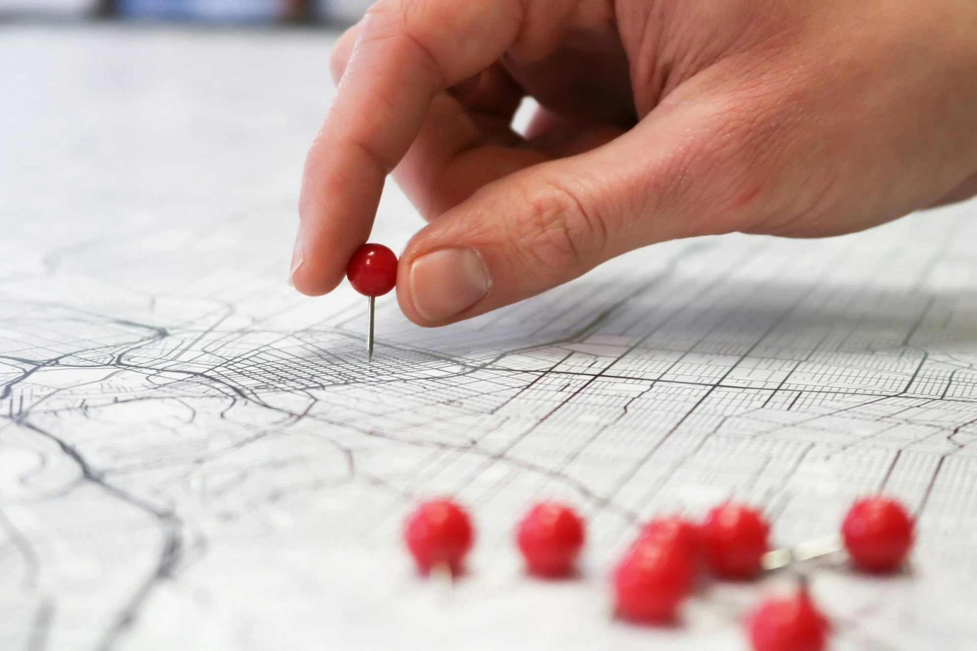 Someone placing pins on a map.