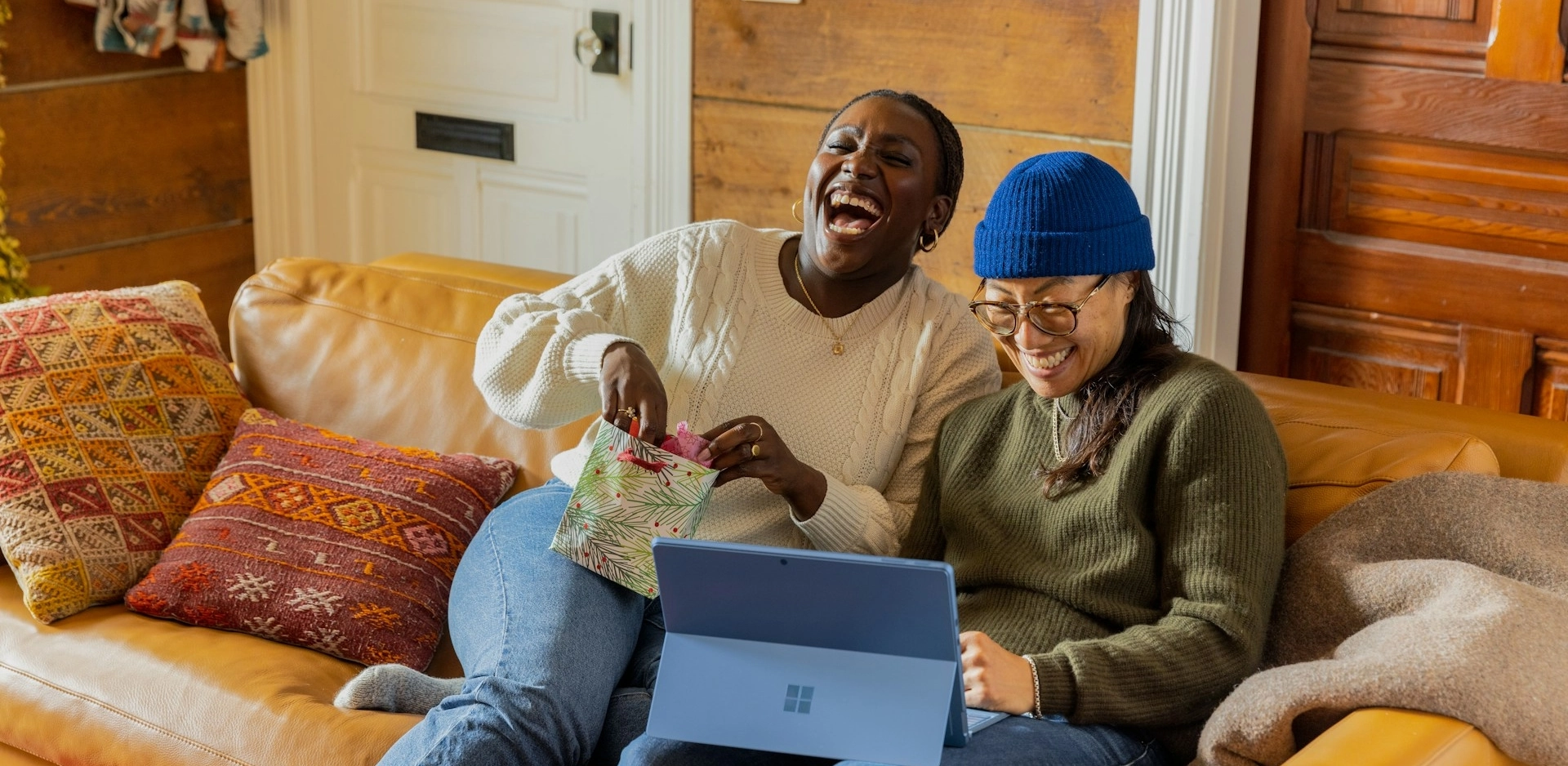 Two friends laughing on a sofa