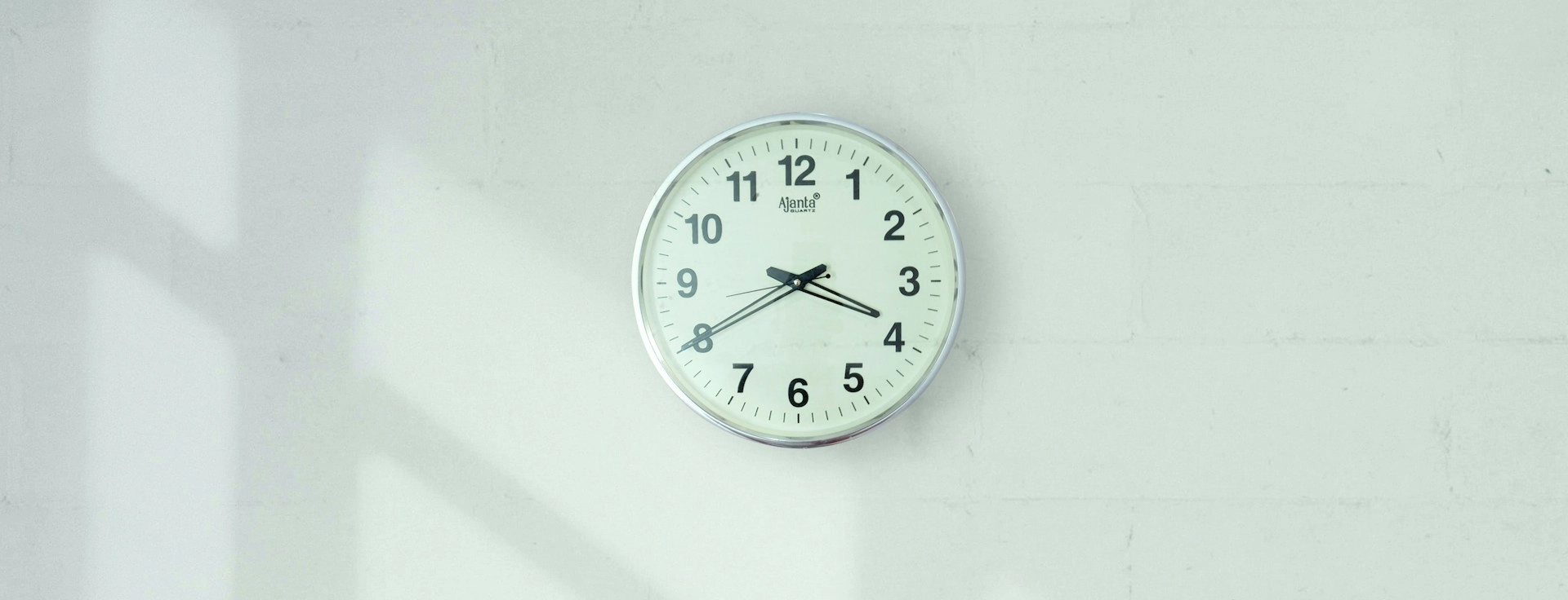 Wall clock hanging against a white wall