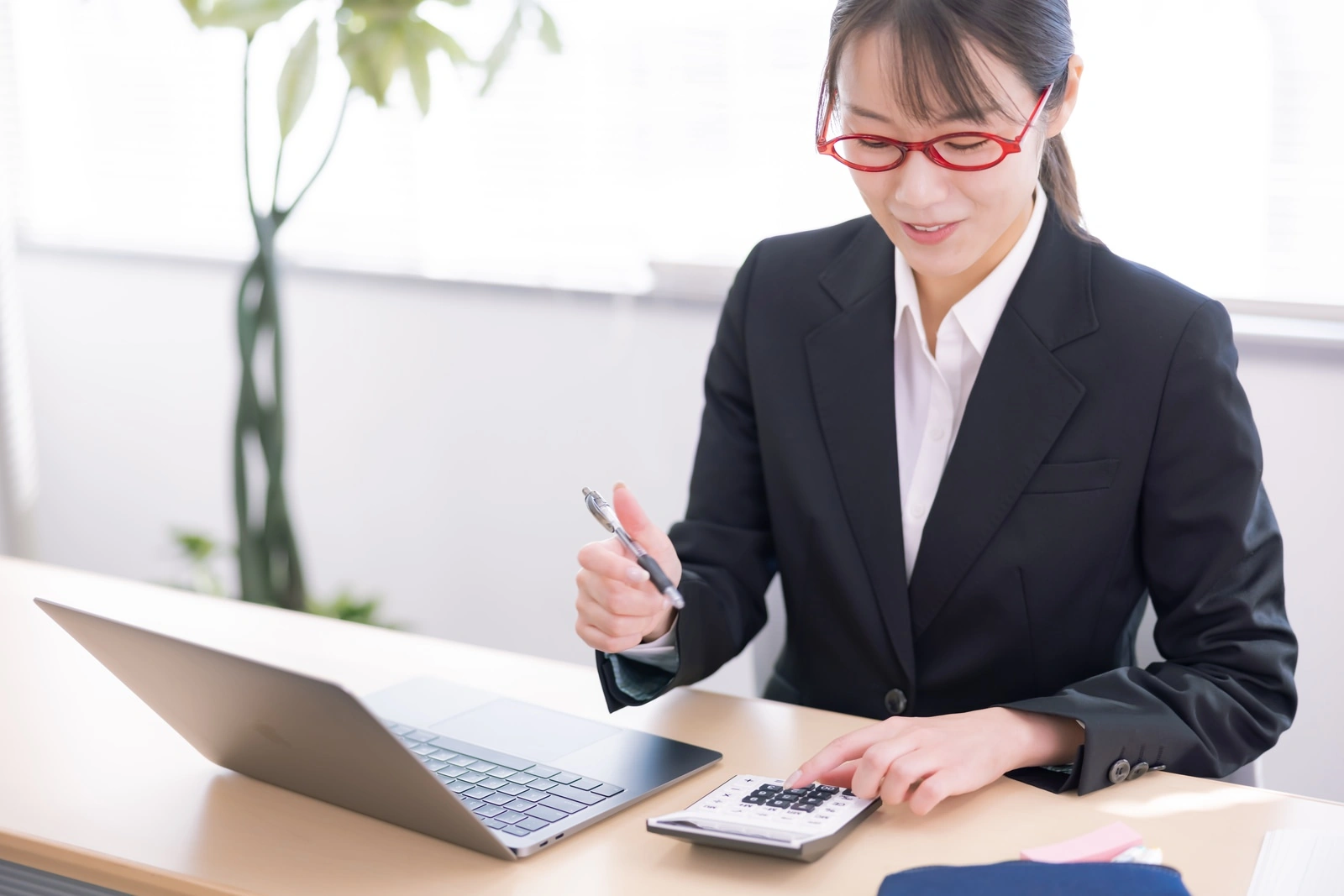 パソコンで計算する人。