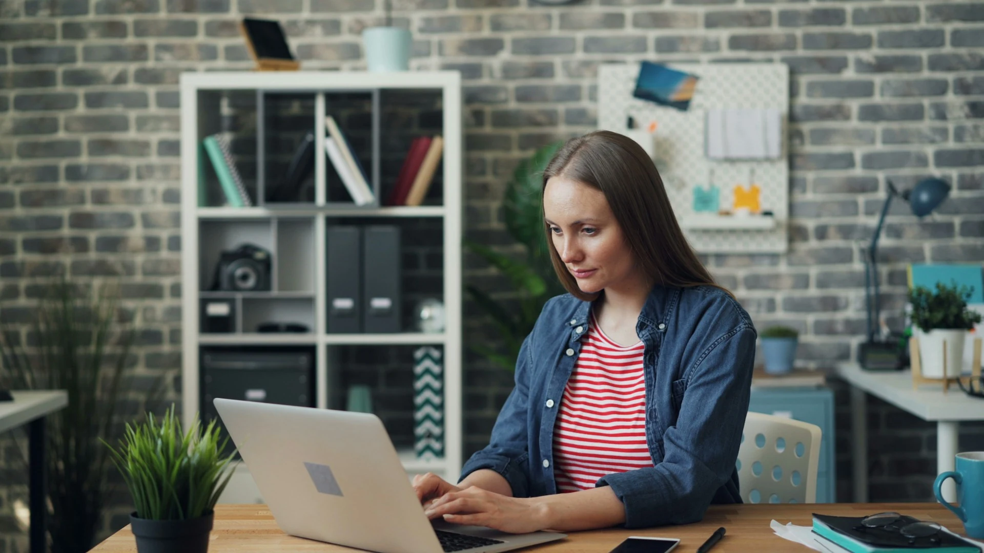 A woman working on her laptop in the office.