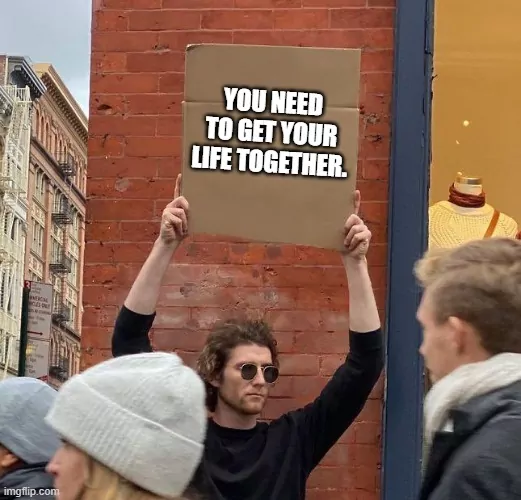 A guy holding up a sign that says "You need to get your life together".