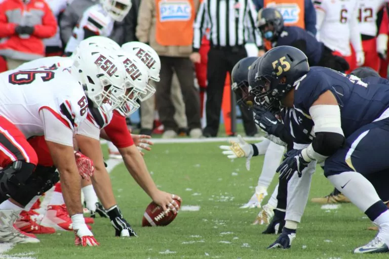 Two football teams on the field, preparing to start the game.