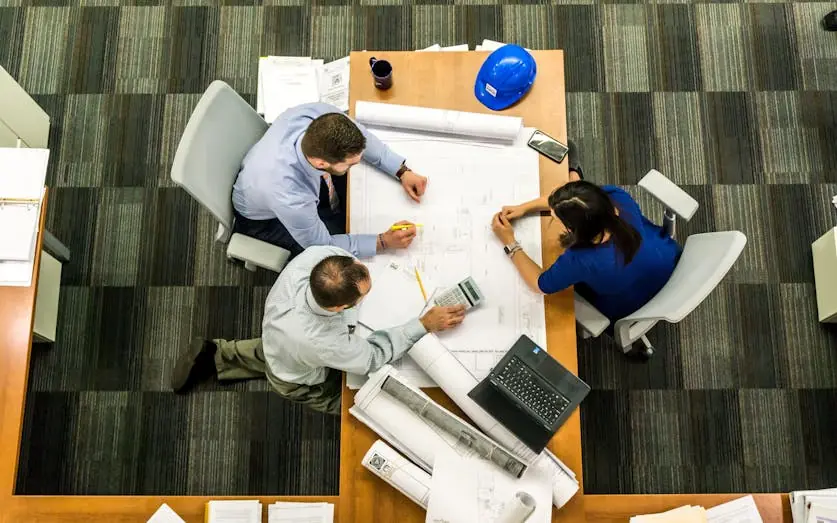 Builders analyzing plans and budgets, trying to avoid insolvency.