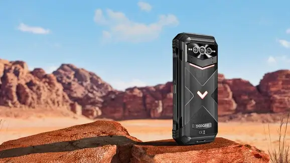 Teléfono resistente Doogee V Max Plus sobre una roca con un paisaje desértico al fondo.