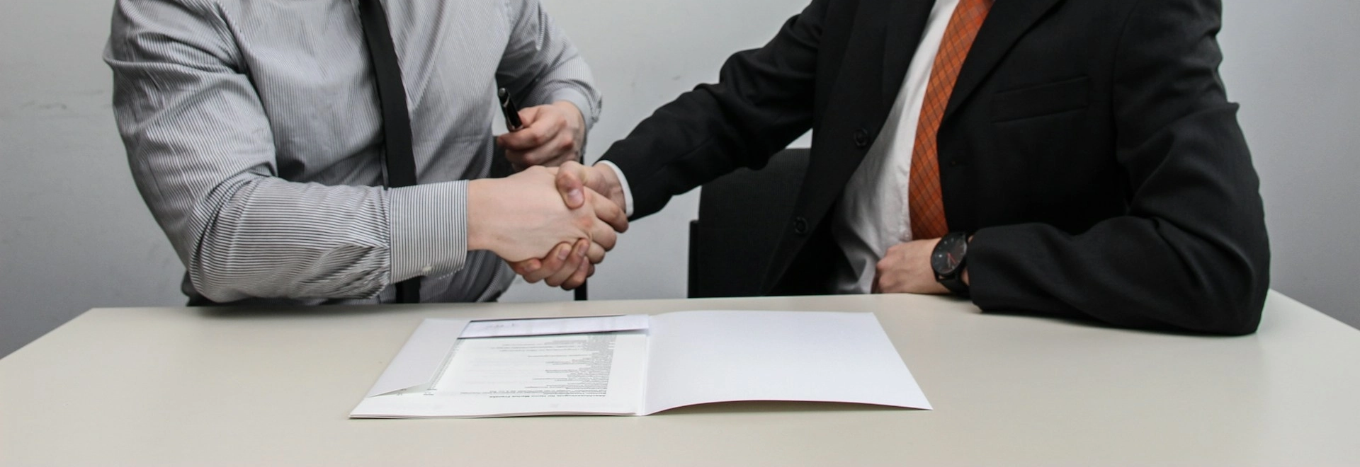 Two men shaking hands after a business deal.