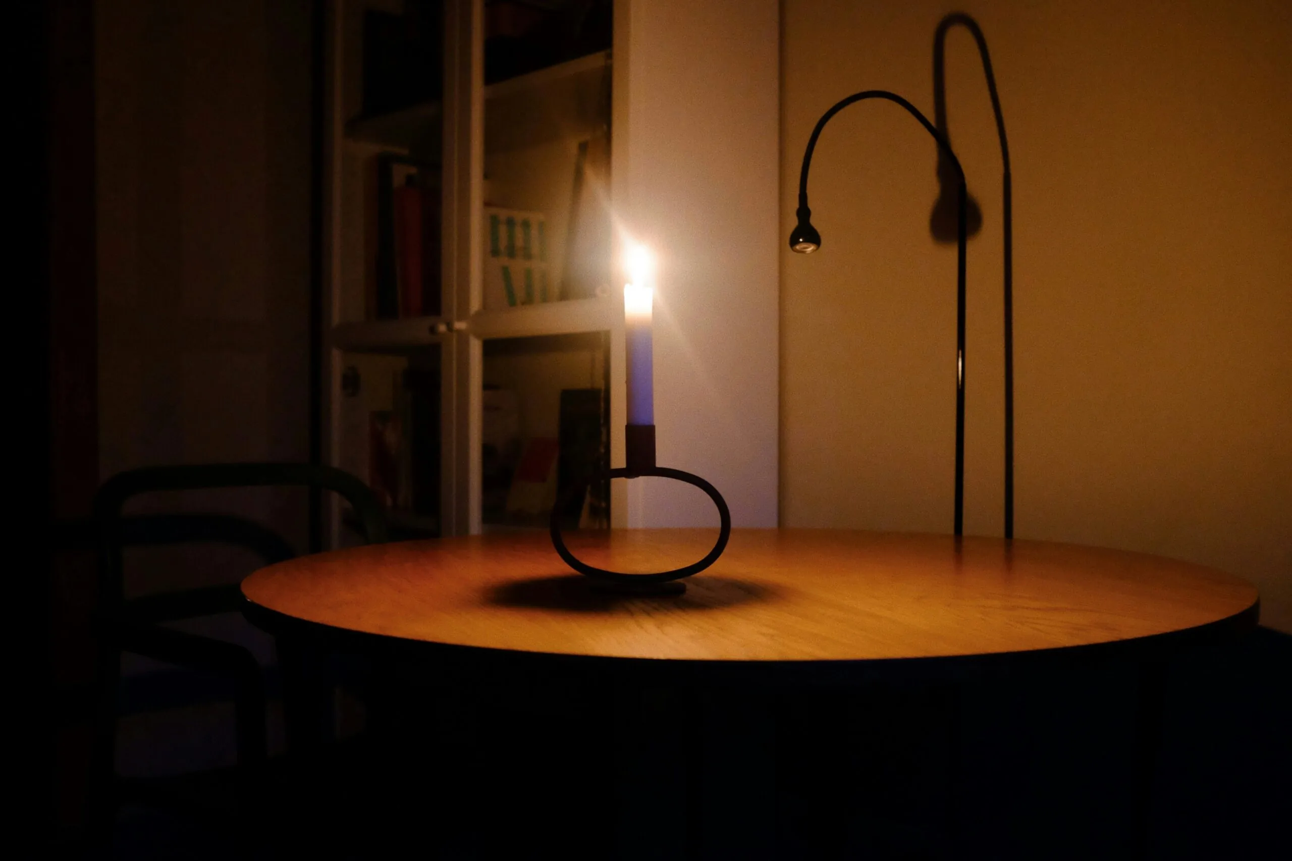 A lit candle on a table in a dark room