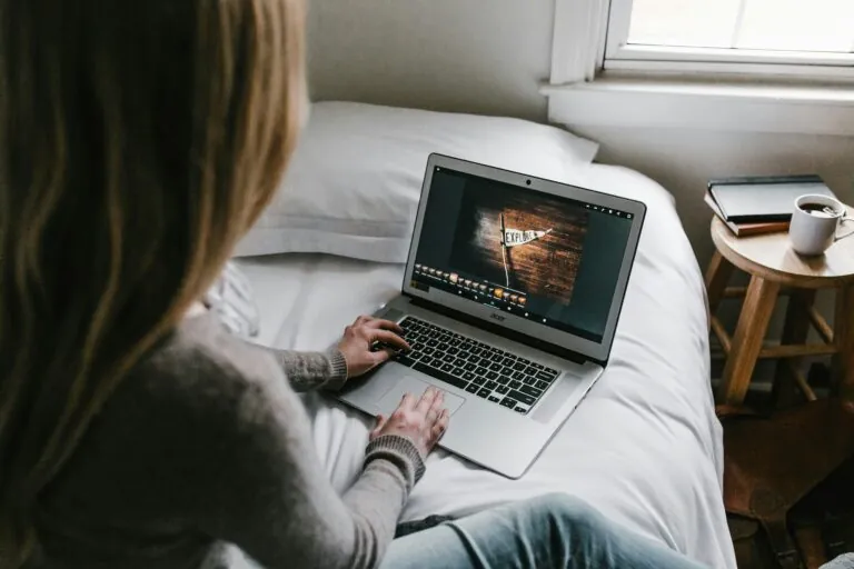 Woman sitting on a bed using a laptop