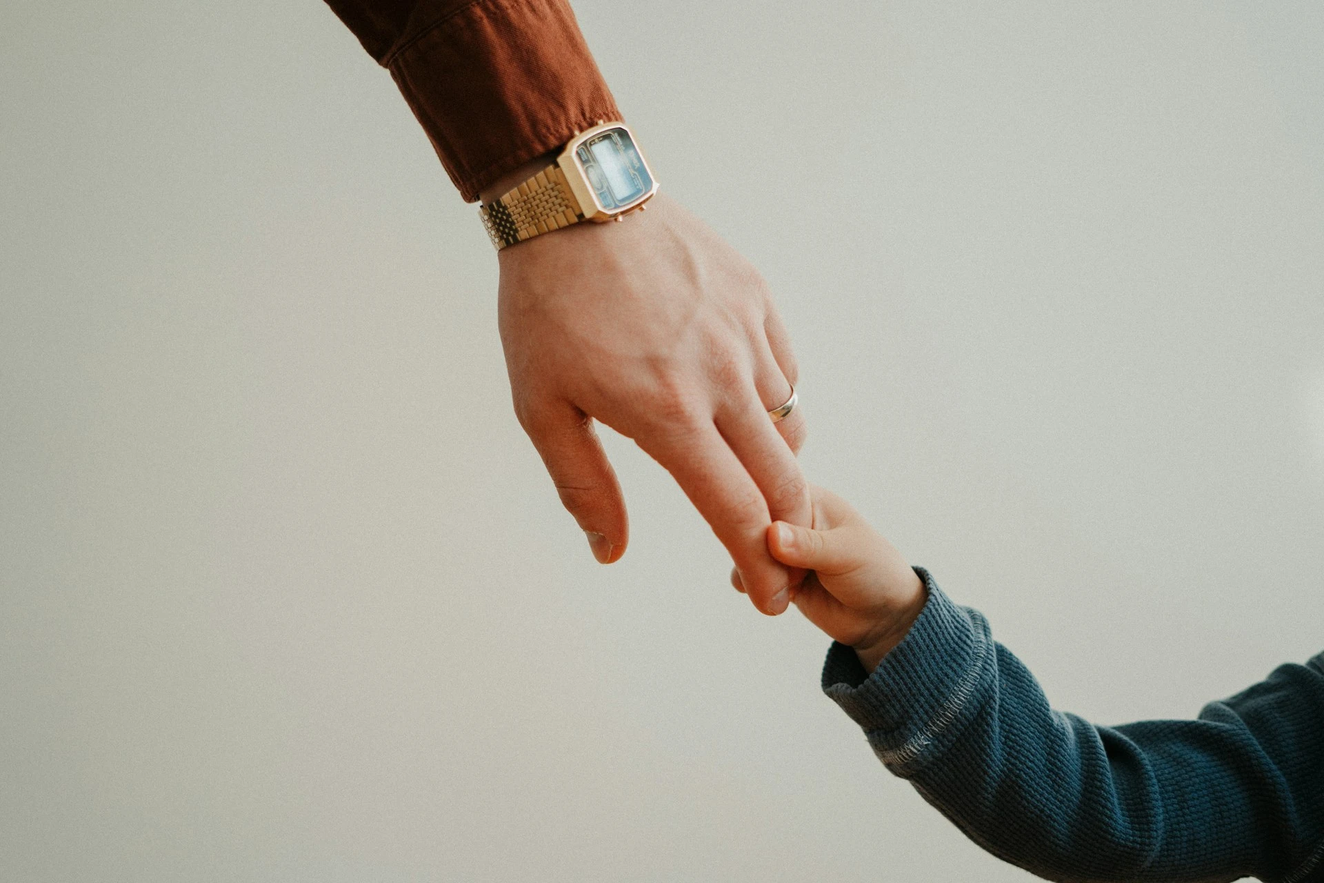 Una persona que sostiene la mano de un niño
