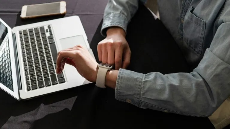 Person with watch on laptop