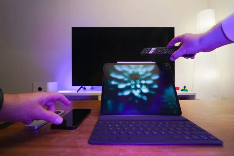 Image of a laptop, a TV, and a mobile phone being used at the same time
