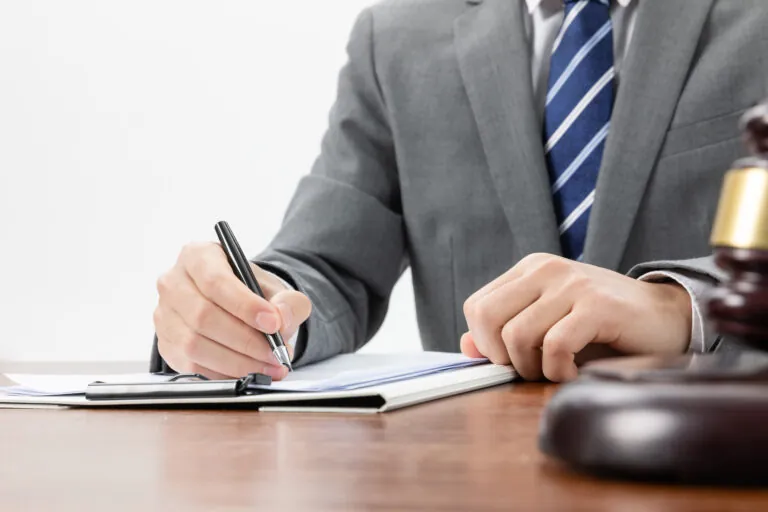 A close-up image of a businessman signing official documents.