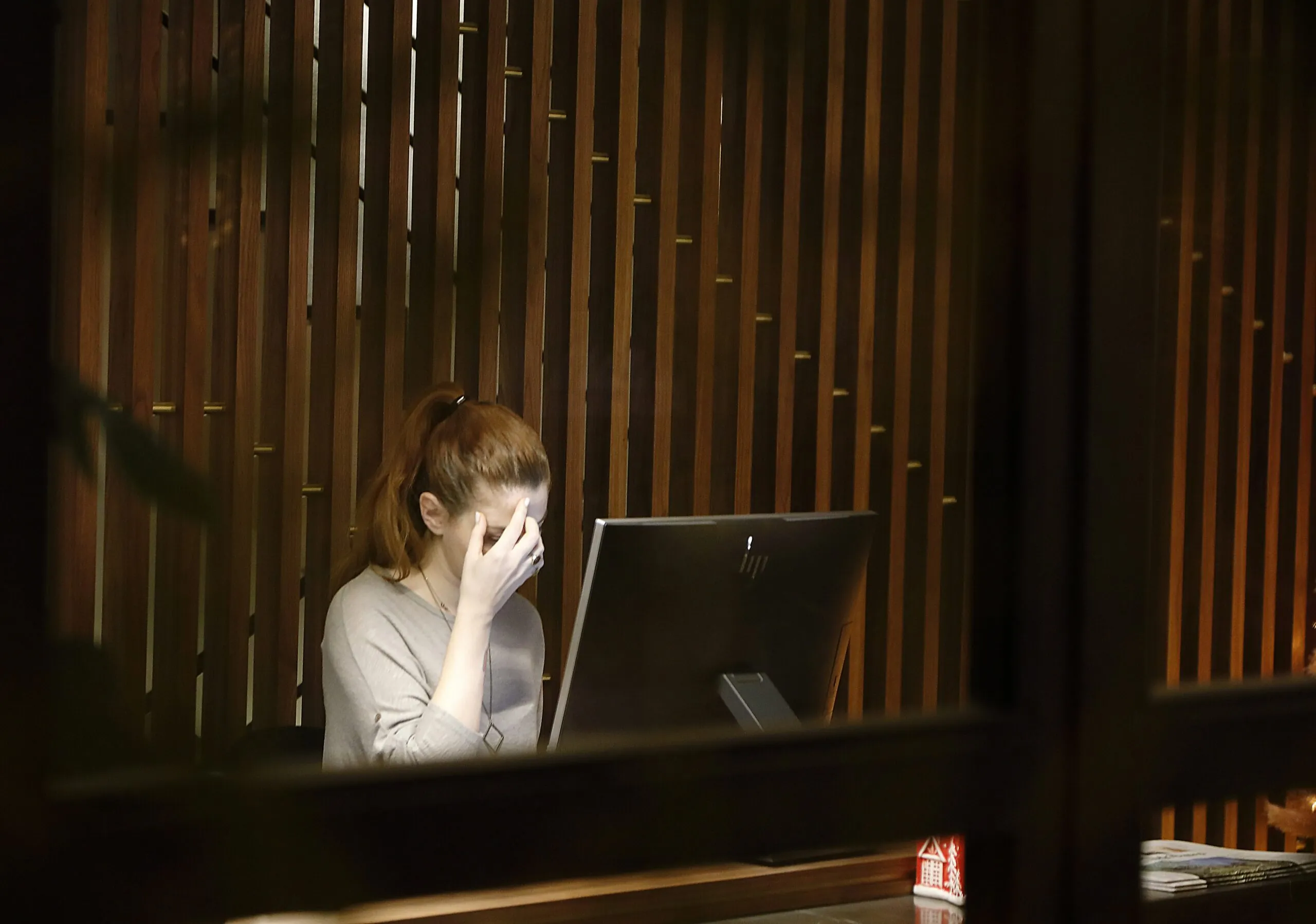 An overworked employee sitting at a desk in front of a computer