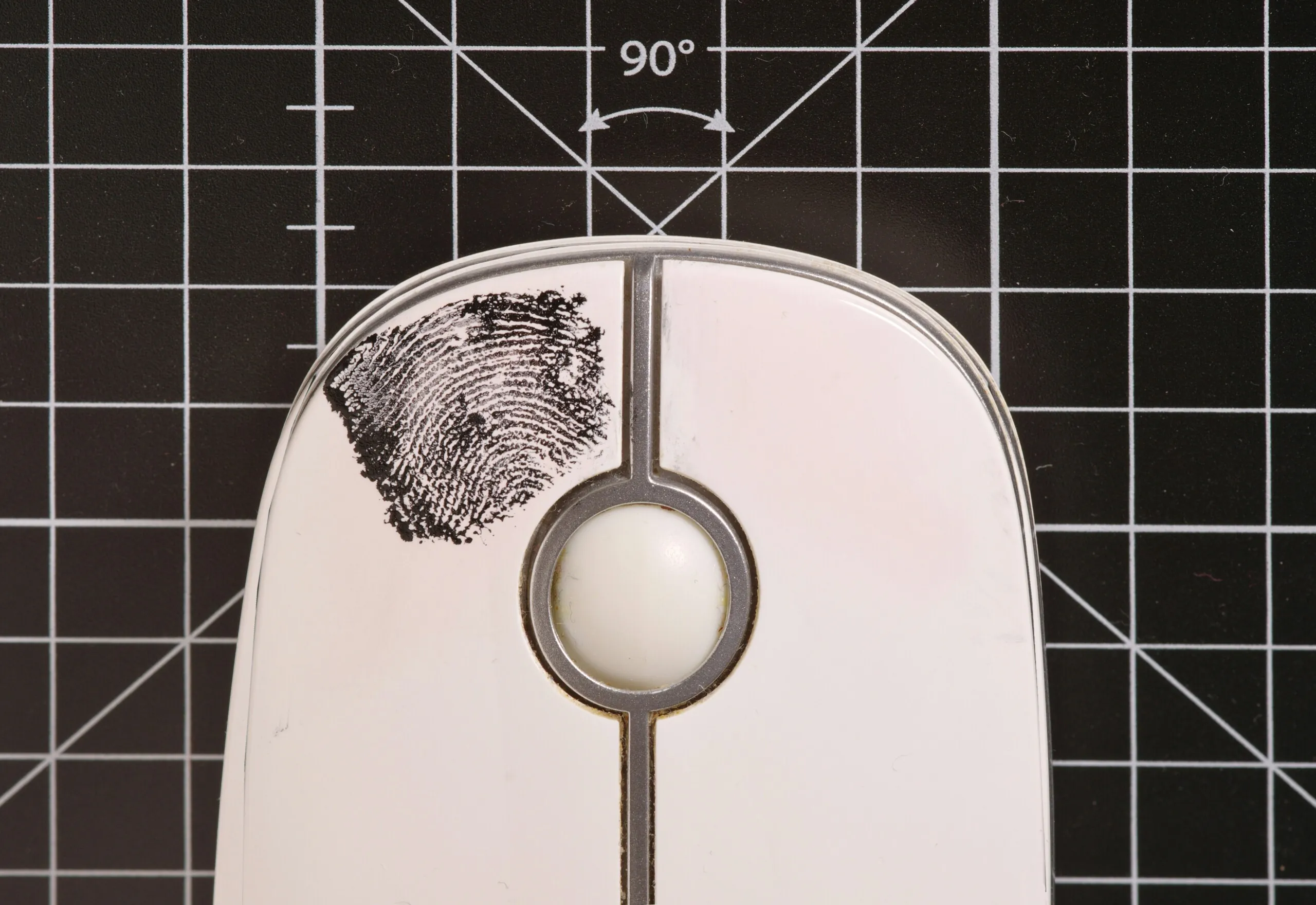 A close up of a computer mouse with a finger print mark on it.