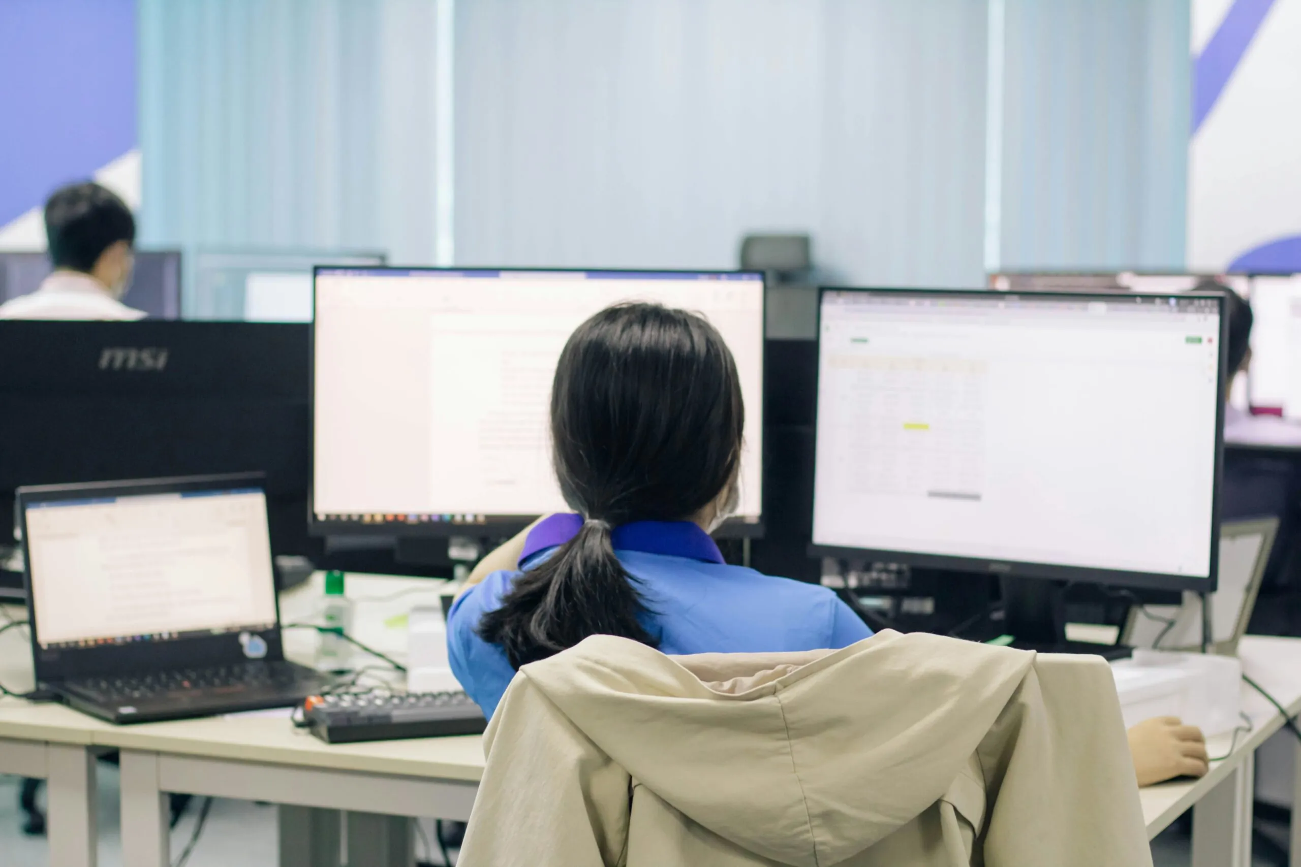 Government employee monitoring, woman sitting at desk working on computer.