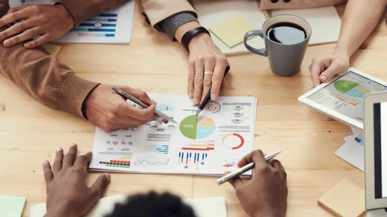 Persone che lavorano a dei grafici su un tavolo