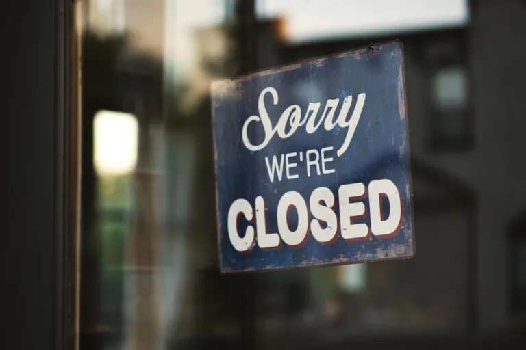 Cartello su una vetrina che dice "Sorry we're closed"