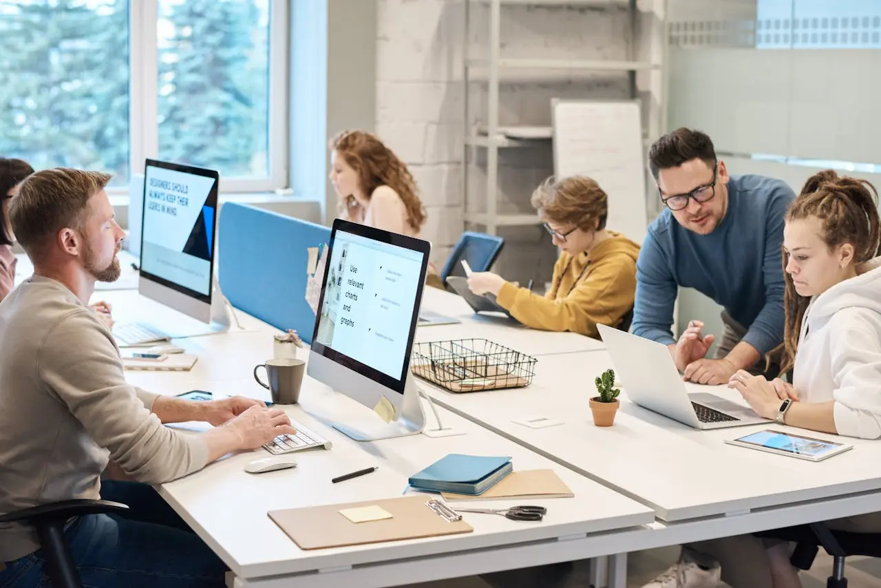 A group of employees working at a shared table in the office.