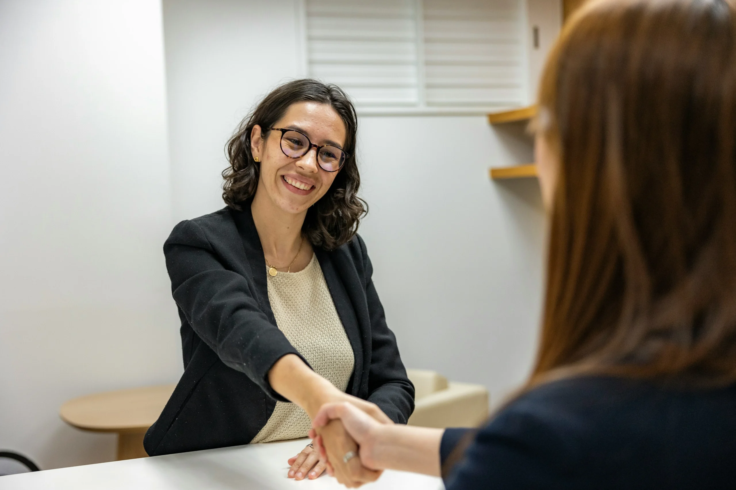 Due donne che si stringono la mano in un ufficio.