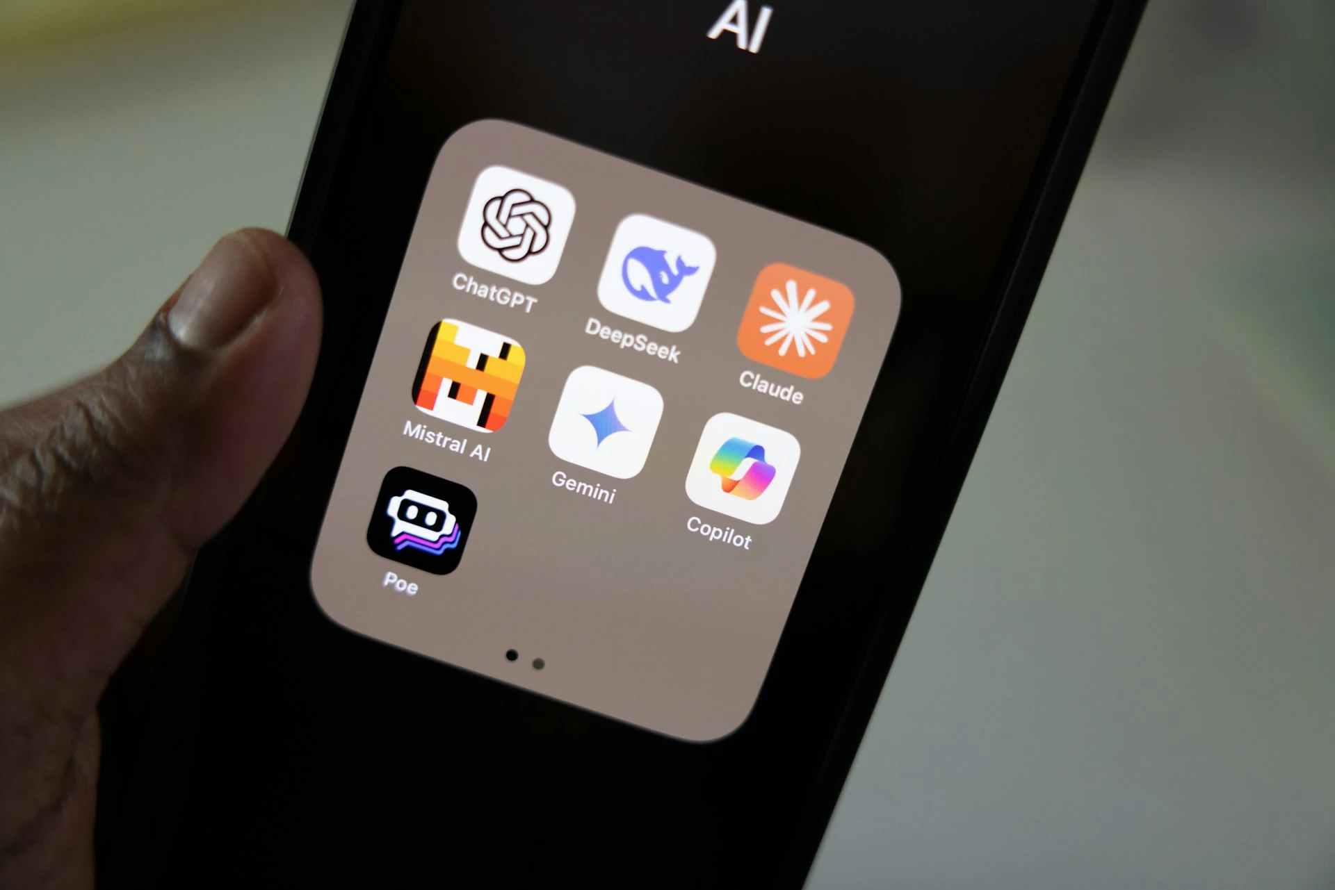 A person holds a smartphone with AI apps.